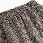 Detalje af houndstooth-bukser: elastisk linning og folder ved taljen.