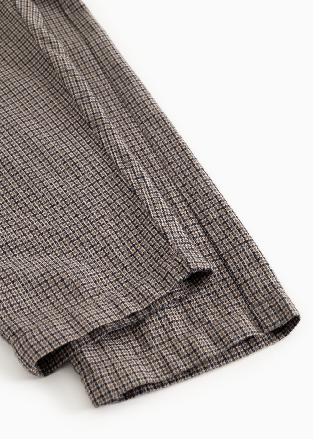 Detalje af bukseben med houndstooth-mønster og lille manchet i bunden.