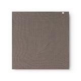 Airo tørklæde med houndstooth-tern i mørkebrun og blå, foldet firkant