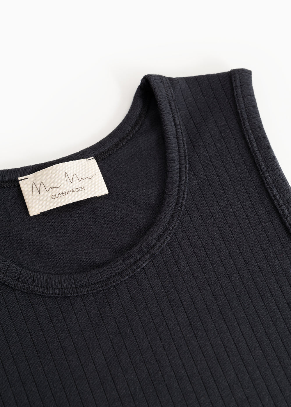 Sort tanktop med rund halsudskæring og synlig mærkelabel ved kraven
