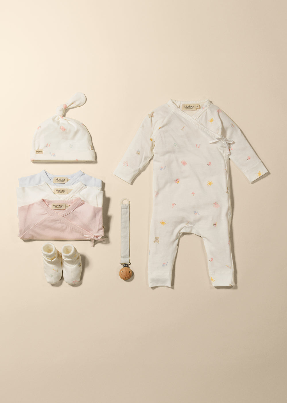Heldragt med matching sæt: offwhite heldragt, hue og sokker i samme flerfarvede print.