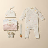 Baby tøj-sæt i hvidt og rosa: hue, dragt med lange ærmer og sokker.