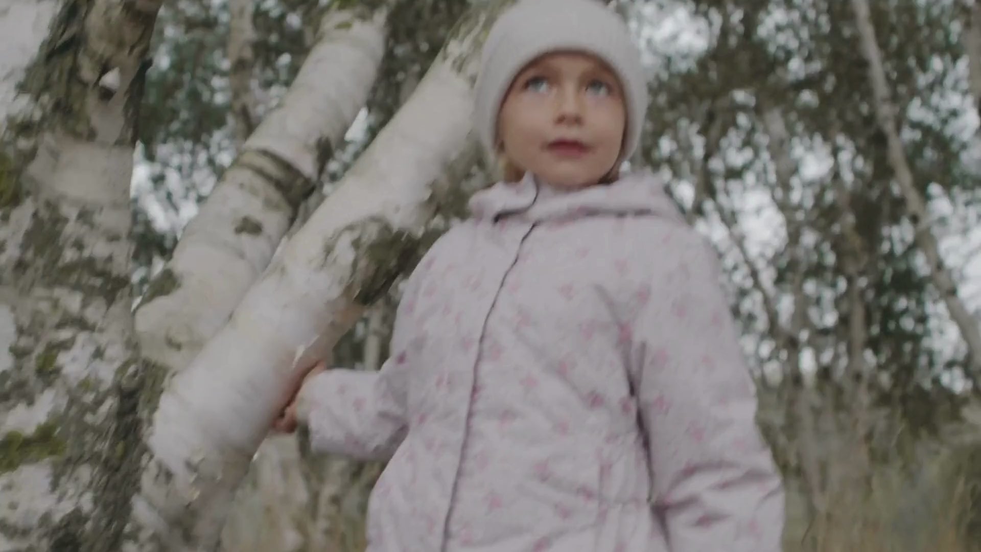 Barn iført lyserød termojakke med blomstermønster og hue